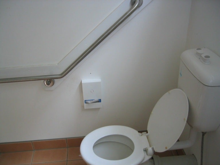 Handrail installed upside down - should lead down towards toilet not up and away