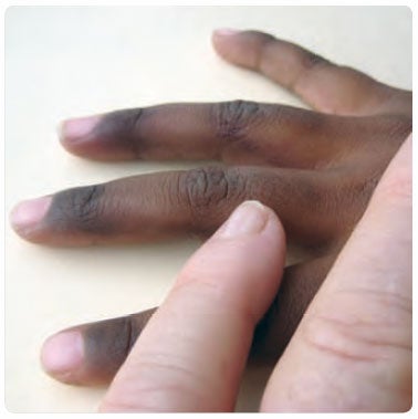 White person and Indigenous person's hands together
