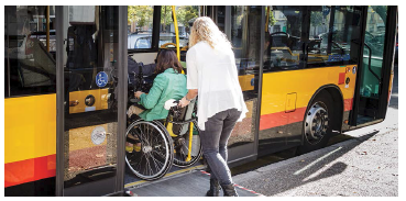 Person with wheelchair using ramp to access bus