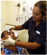 Picture of a health worker administering eye drops to a patient