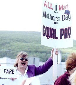 Image: Woman protester with sign that reads "All I want for Mother's Day is Equal Pay!" Photograph by Shannon de Celle
