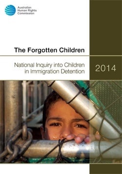 Cover of The Forgotten Children 2014 Report. The face of a young boy standing behind a locked gate. 