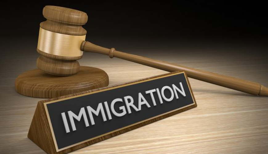 A court gavel sits behind a sign saying immigration